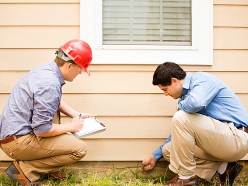 inspecting base of house